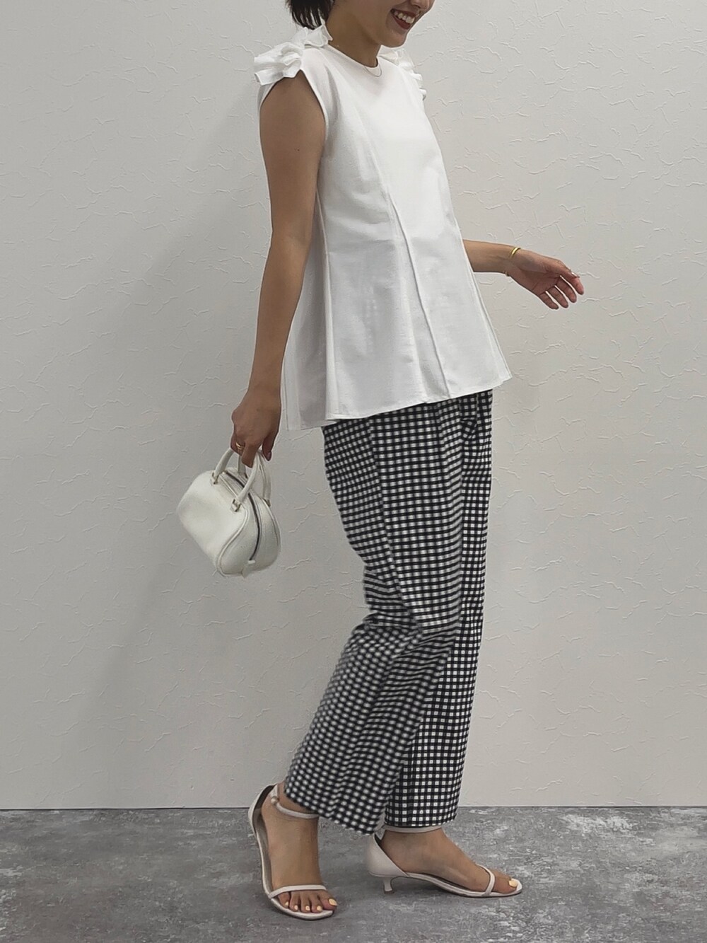 ブラック系のその他パンツ、ホワイト系のTシャツ/カットソー、ホワイト系のボストンバッグを着用したレディースの春コーディネートの4枚目の写真