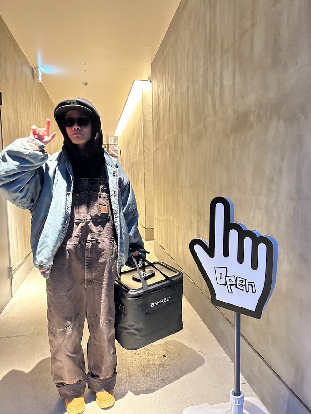 ブルー系のスカジャン、ブラック系のパーカー、ブラウン系のサロペット/オーバーオールを着用したメンズの冬コーディネートの3枚目の写真