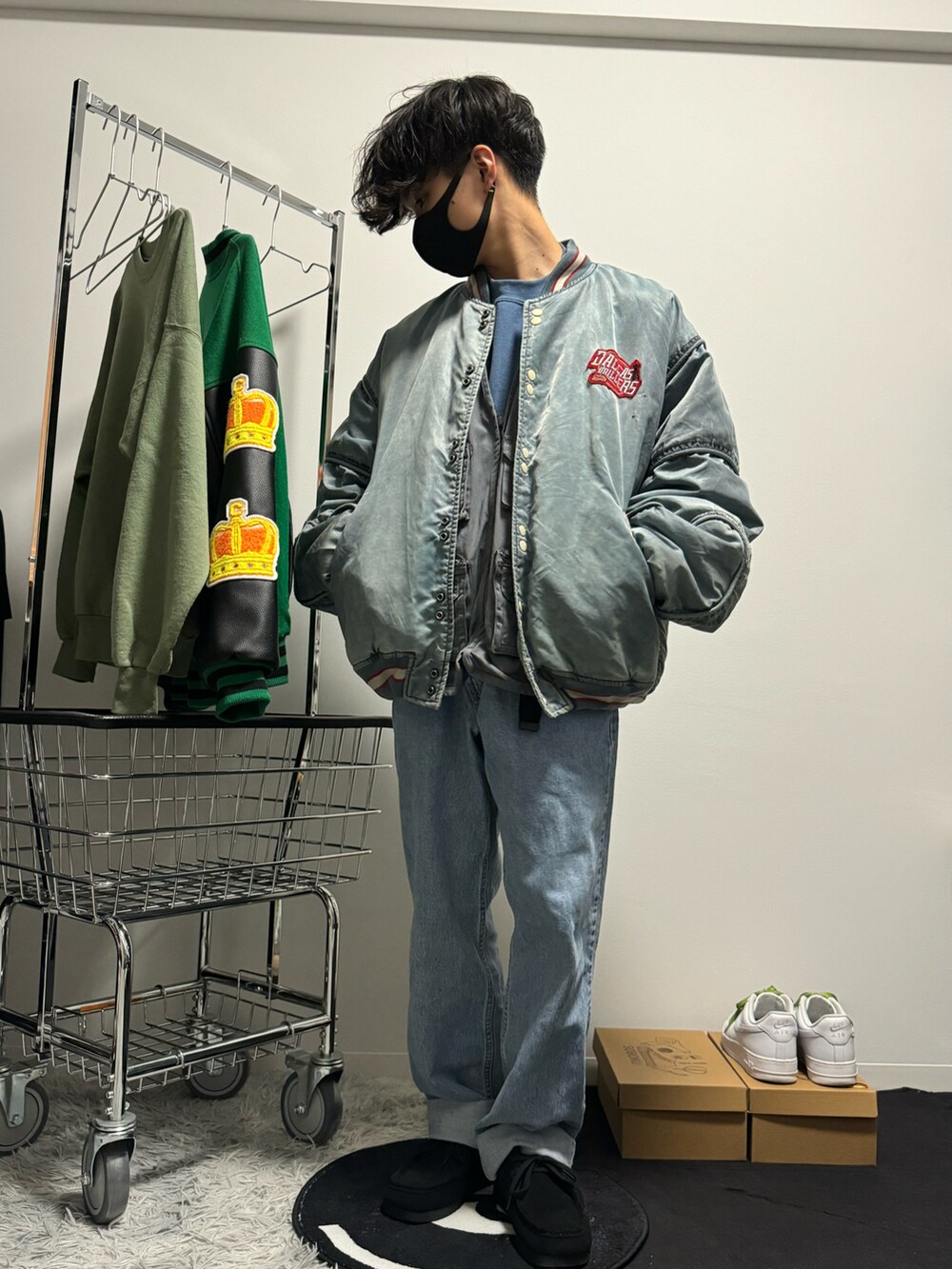 ブルー系のスタジャン、ブルー系のデニムパンツ、ブラック系のモカシン/デッキシューズを着用したメンズの春コーディネートの2枚目の写真