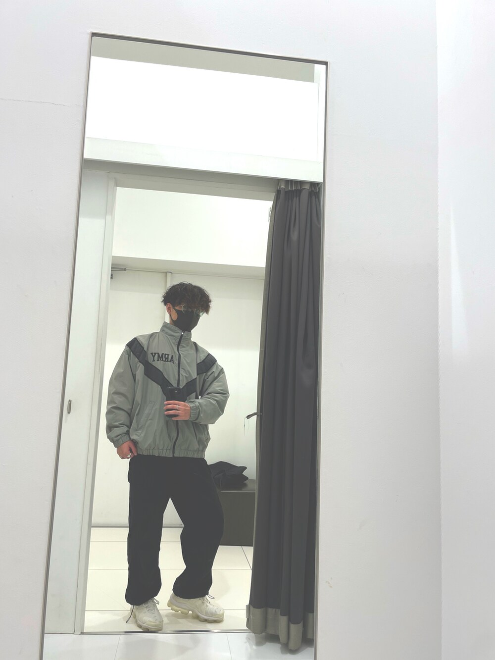 グリーン系のナイロンジャケット、ブラック系のカーゴパンツ、ホワイト系のスニーカーを着用したメンズの冬コーディネートの3枚目の写真