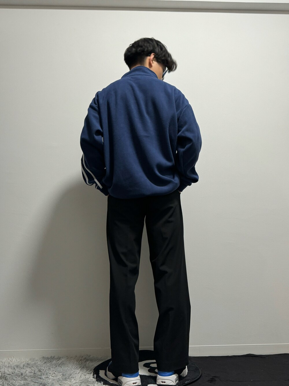 ブルー系のスニーカー、ブラック系のスラックス、ブルー系のスウェットを着用したメンズの春コーディネートの5枚目の写真