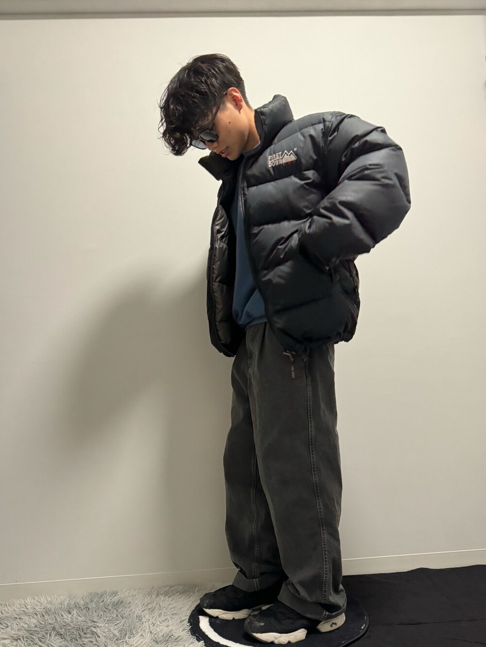 ブラック系のデニムパンツ、ブラック系のダウンジャケット/コート、ブルー系のスウェットを着用したメンズの冬コーディネートの5枚目の写真