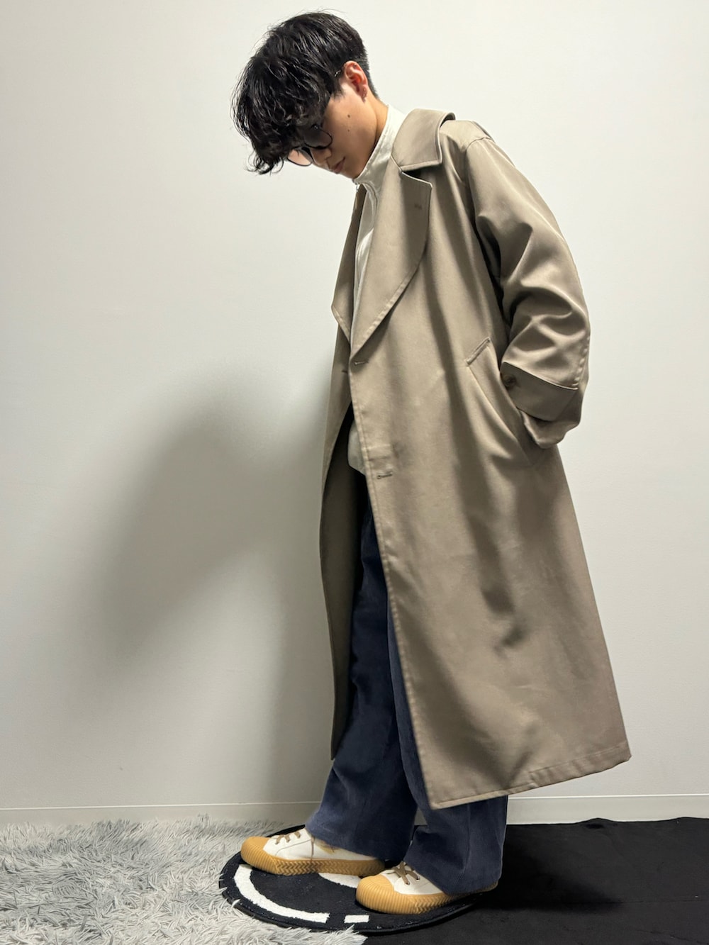 ベージュ系のトレンチコートを着用したメンズの春コーディネートの2枚目の写真
