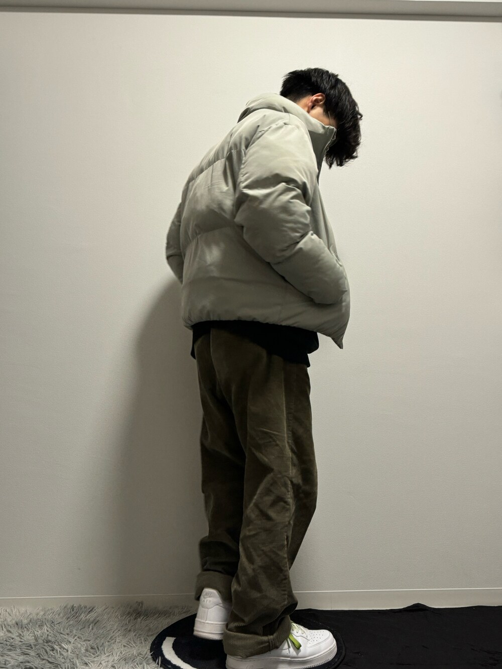 グレー系のダウンジャケット/コート、グリーン系のその他パンツ、ホワイト系のスニーカーを着用したメンズの春コーディネートの5枚目の写真