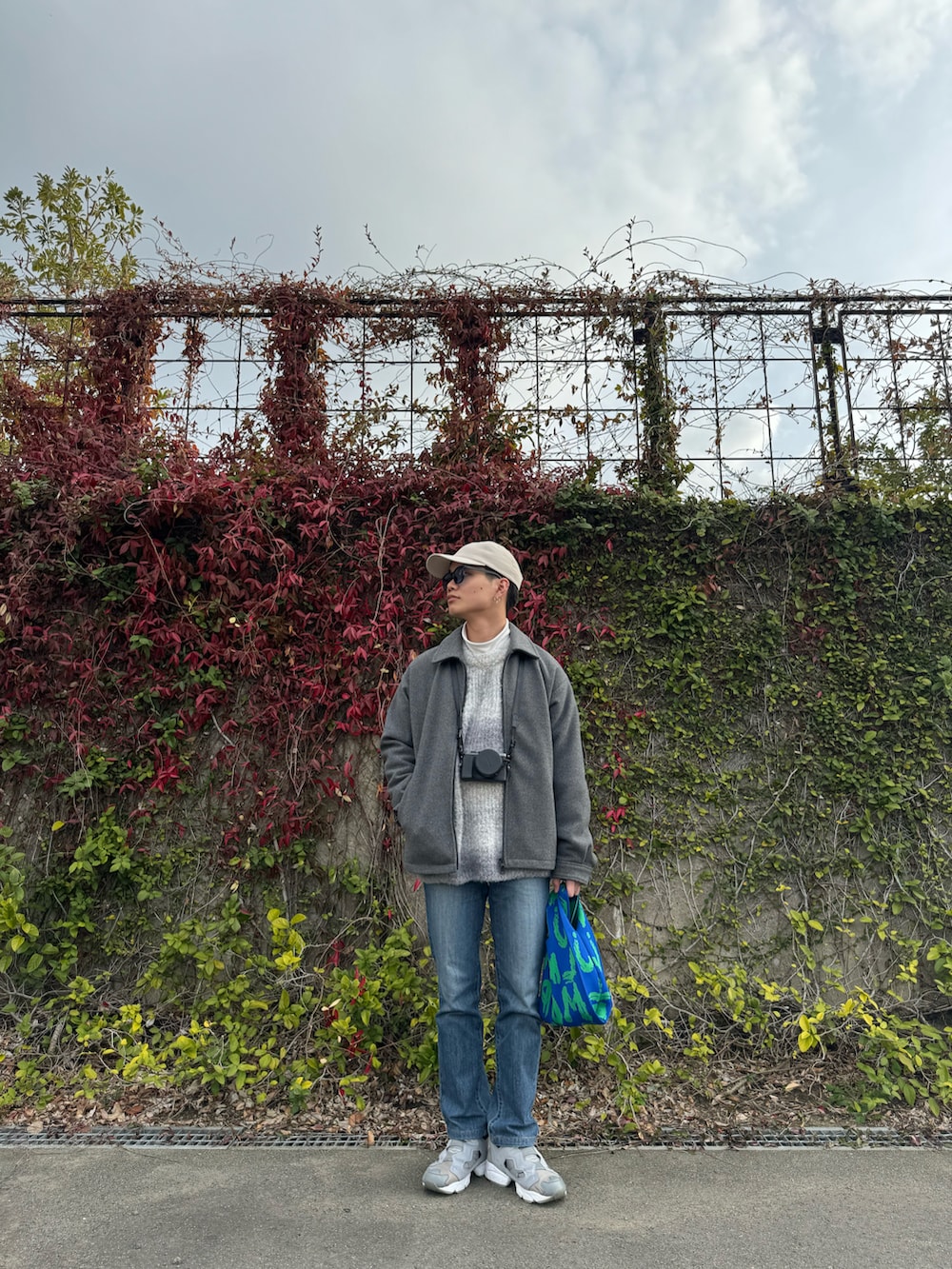 グレー系のニット/セーター、グレー系のブルゾン、ブルー系のデニムパンツを着用したメンズの冬コーディネートの3枚目の写真