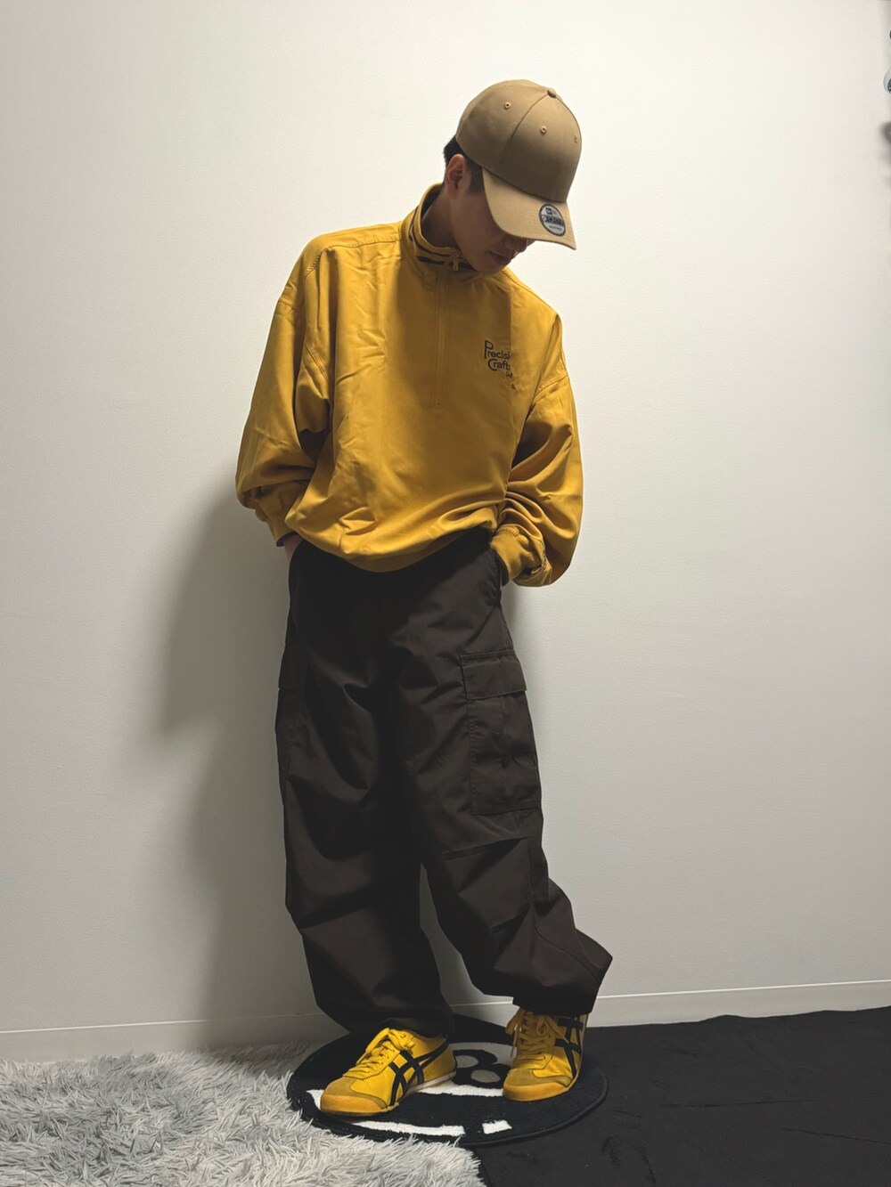 イエロー系のスウェット、ブラウン系のカーゴパンツ、イエロー系のスニーカーを着用したメンズの冬コーディネートの3枚目の写真