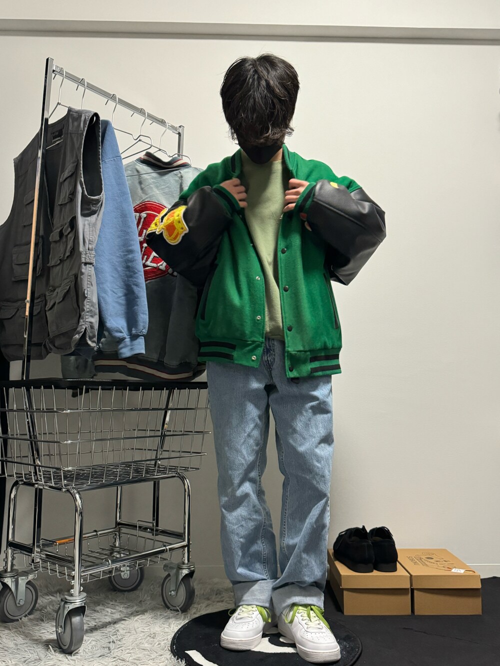 ブルー系のデニムパンツ、ホワイト系のスニーカー、グリーン系のタンクトップを着用したメンズの冬コーディネートの2枚目の写真