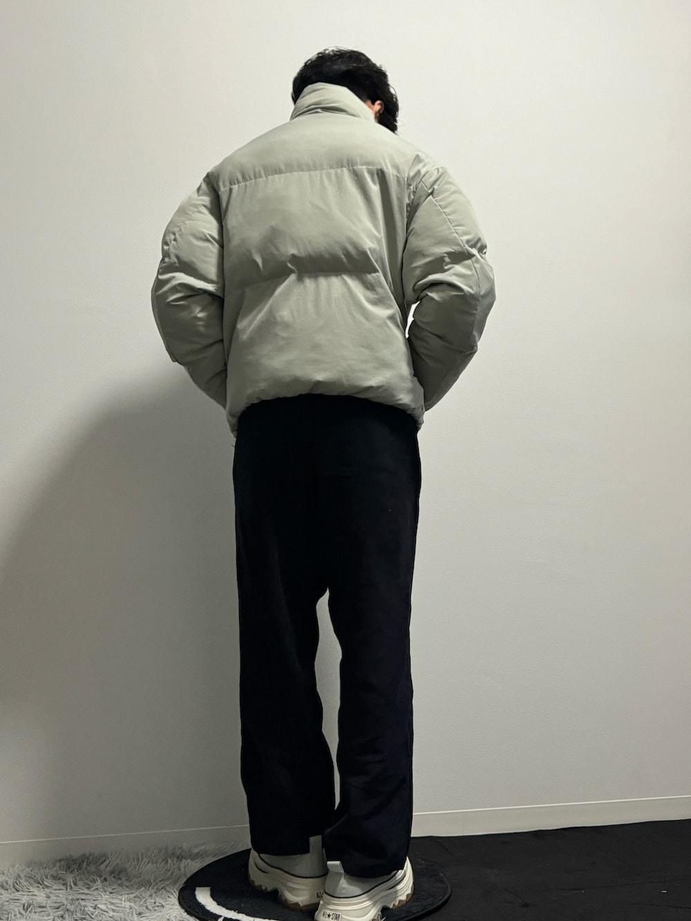 グレー系のダウンジャケット/コート、ブラック系のその他パンツ、グレー系のスニーカーを着用したメンズの春コーディネートの5枚目の写真