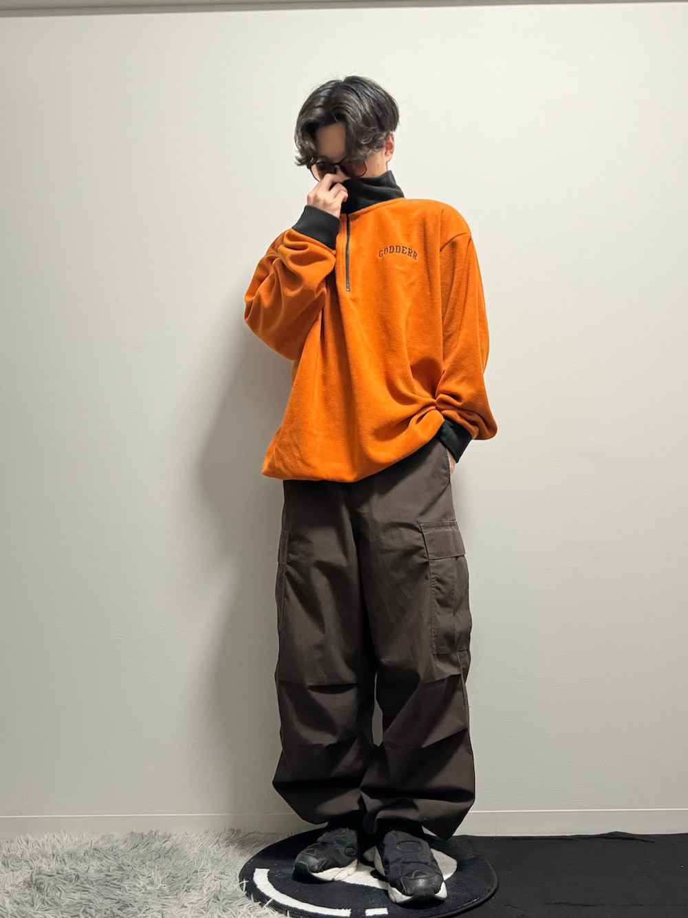 ブラウン系のカーゴパンツ、グレー系のスニーカー、オレンジ系のスウェットを着用したメンズの春コーディネートの2枚目の写真