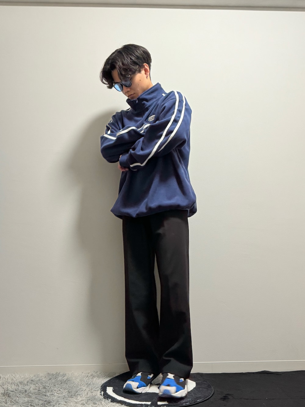 ブルー系のスニーカー、ブラック系のスラックス、ブルー系のスウェットを着用したメンズの春コーディネートの2枚目の写真