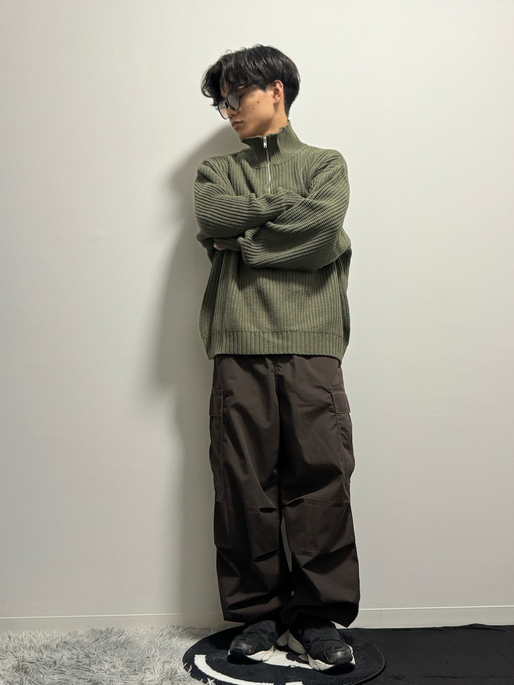 グリーン系のニット/セーター、ブラウン系のカーゴパンツ、ブラック系のスニーカーを着用したメンズの春コーディネートの5枚目の写真