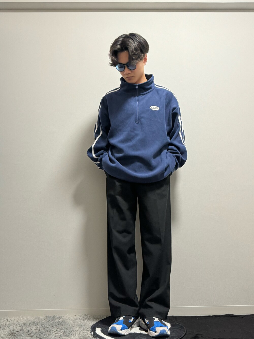 ブルー系のスニーカー、ブラック系のスラックス、ブルー系のスウェットを着用したメンズの春コーディネートの3枚目の写真