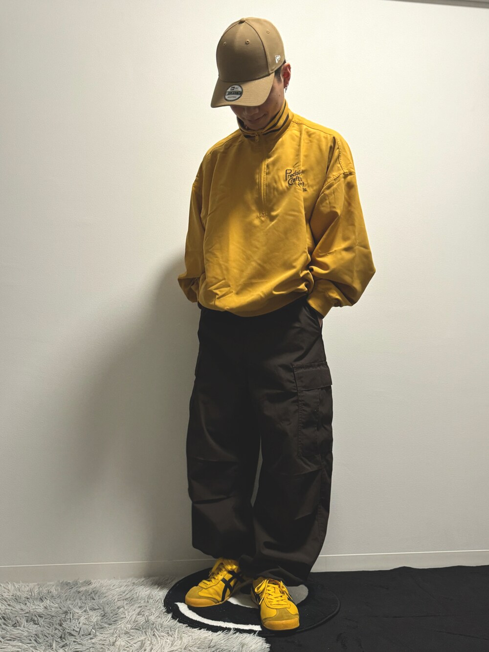 イエロー系のスウェット、ブラウン系のカーゴパンツ、イエロー系のスニーカーを着用したメンズの冬コーディネートの4枚目の写真