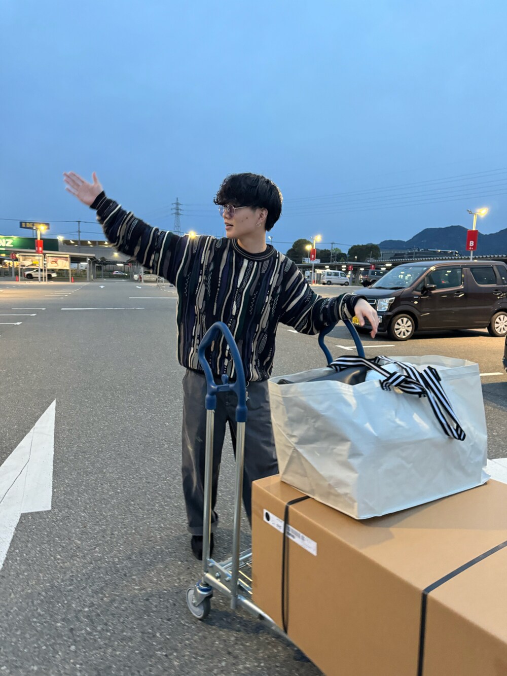 ブラック系のデニムパンツ、ブラック系のモカシン/デッキシューズ、ブラック系のニット/セーターを着用したメンズの春コーディネートの3枚目の写真