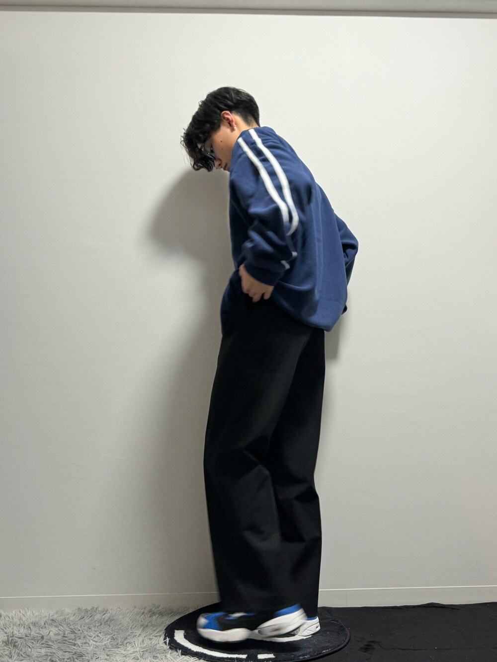 ブルー系のスニーカー、ブラック系のスラックス、ブルー系のスウェットを着用したメンズの春コーディネートの4枚目の写真