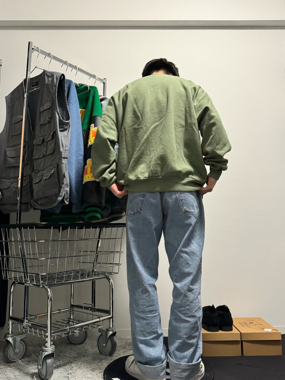 ブルー系のデニムパンツ、ホワイト系のスニーカー、グリーン系のスウェットを着用したメンズの冬コーディネートの4枚目の写真