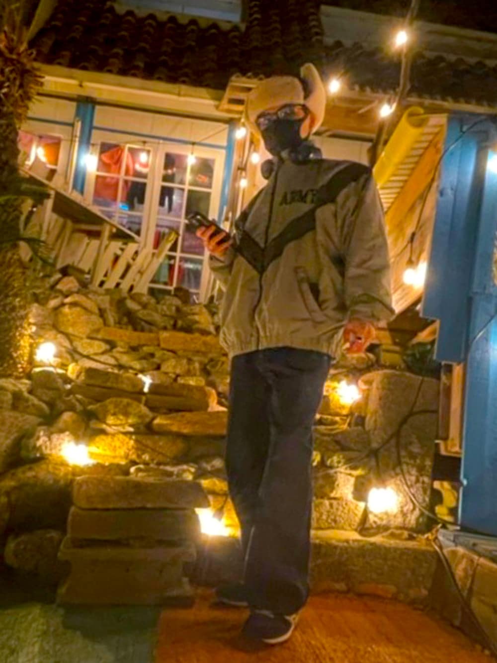 ブルー系のデニムパンツ、グレー系のナイロンジャケット、ブルー系のスニーカーを着用したメンズの冬コーディネートの2枚目の写真