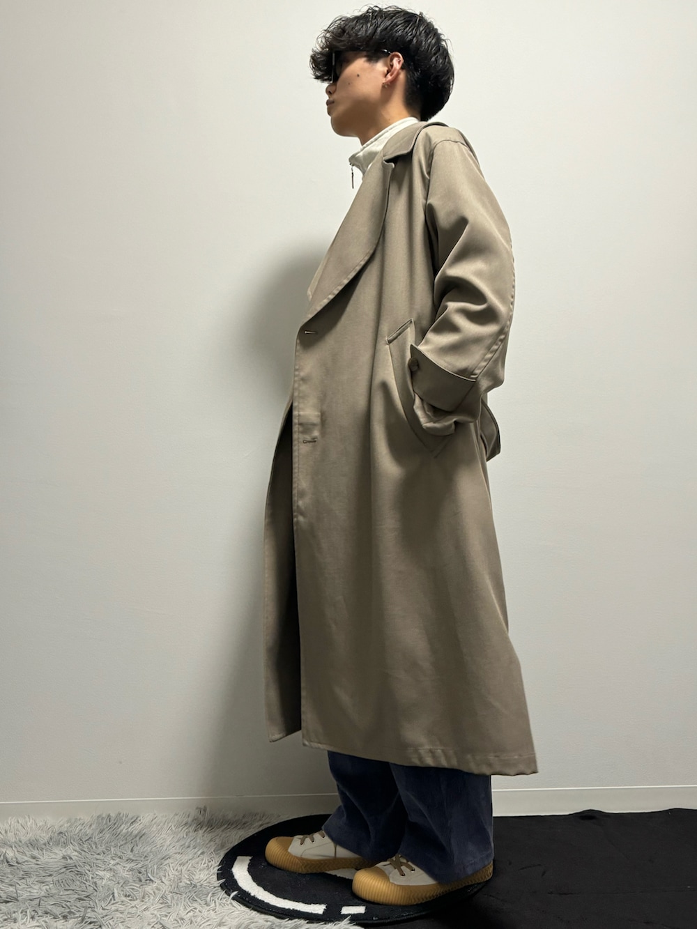 ベージュ系のトレンチコートを着用したメンズの春コーディネートの3枚目の写真