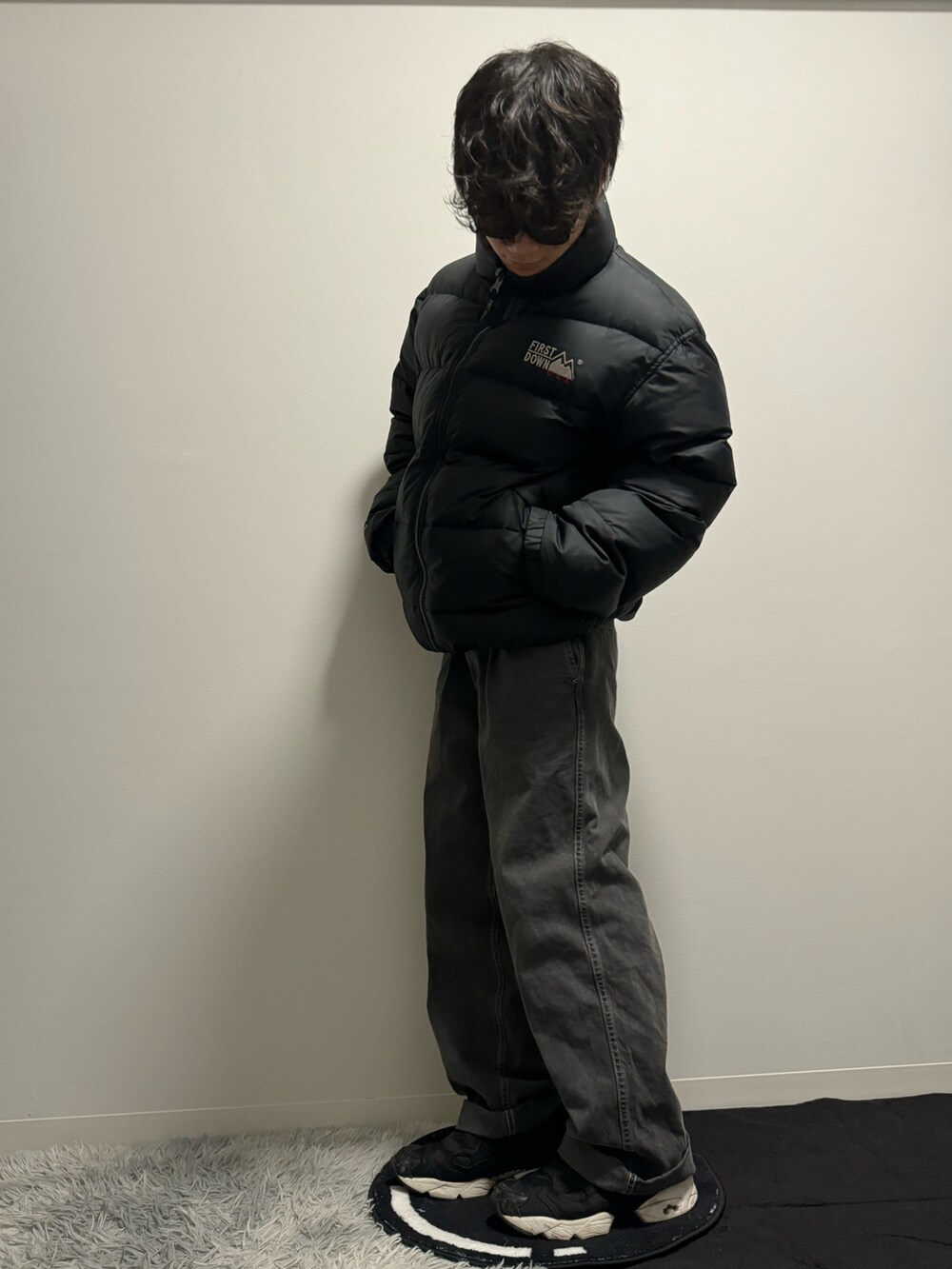 ブラック系のデニムパンツ、ブラック系のスニーカー、ブラック系のダウンジャケット/コートを着用したメンズの冬コーディネートの4枚目の写真