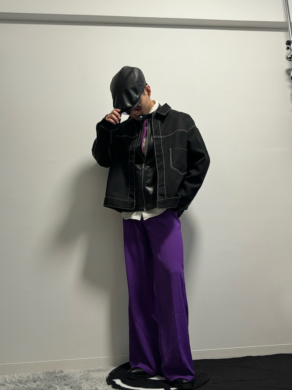 パープル系のスラックス、ブラック系のブーツ、ブラック系のブルゾンを着用したメンズの冬コーディネートの2枚目の写真