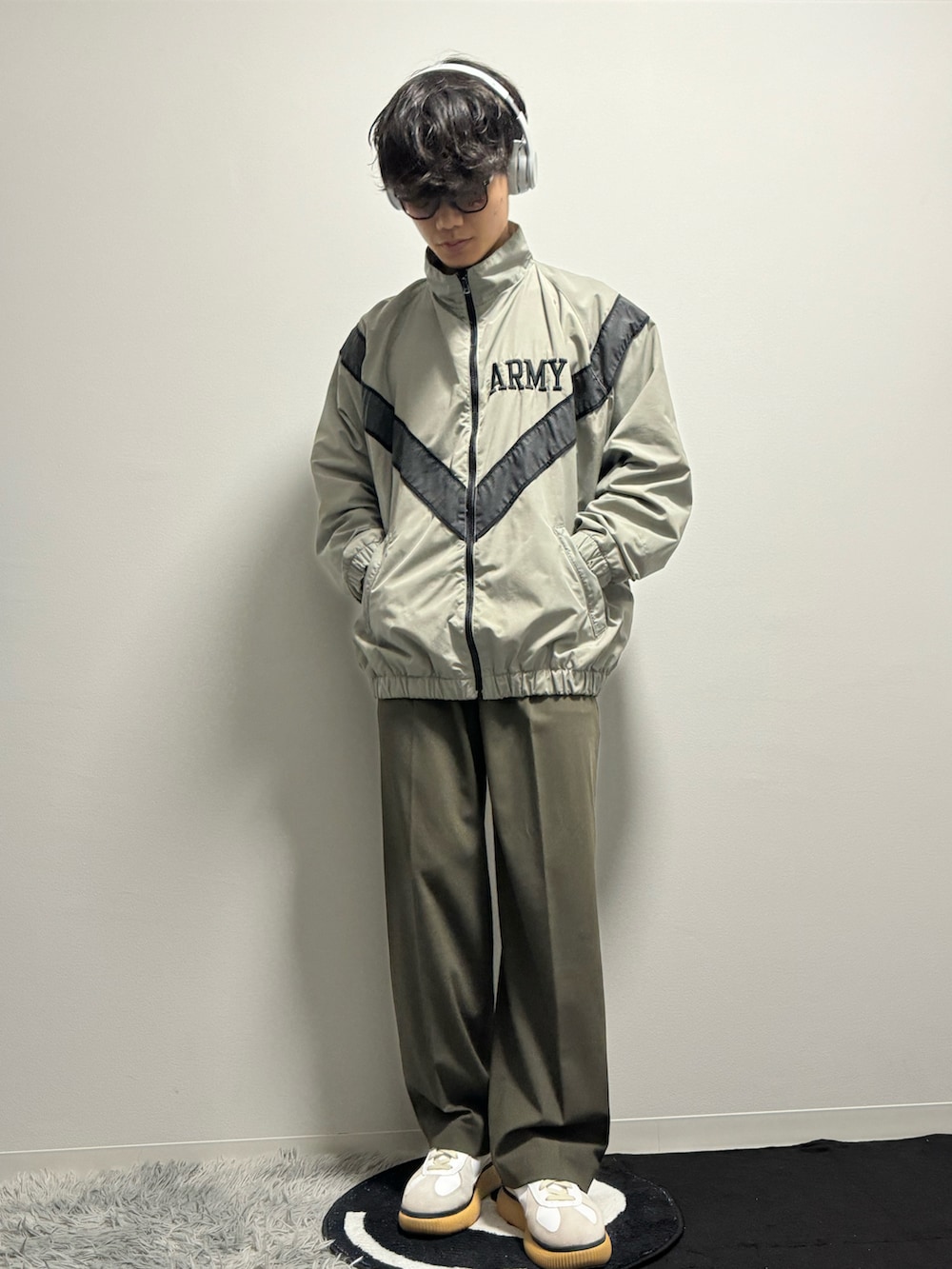 グリーン系のスラックス、グリーン系のスニーカー、グリーン系のミリタリージャケットを着用したメンズの春コーディネートの5枚目の写真