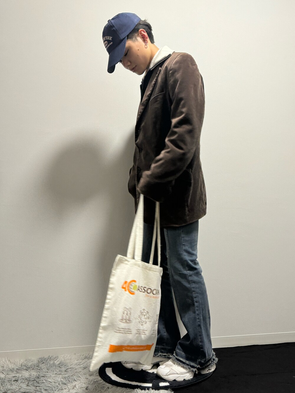 ブラウン系のジャケット/アウター、ブルー系のデニムパンツ、ホワイト系のスニーカーを着用したメンズの春コーディネートの2枚目の写真