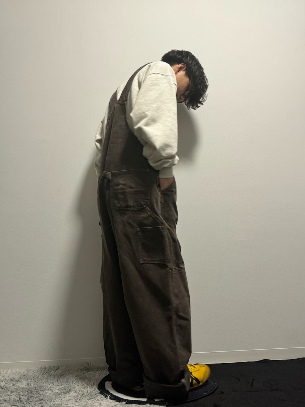 ブラウン系のサロペット/オーバーオール、イエロー系のスニーカー、ブラウン系のスウェットを着用したメンズの春コーディネートの4枚目の写真