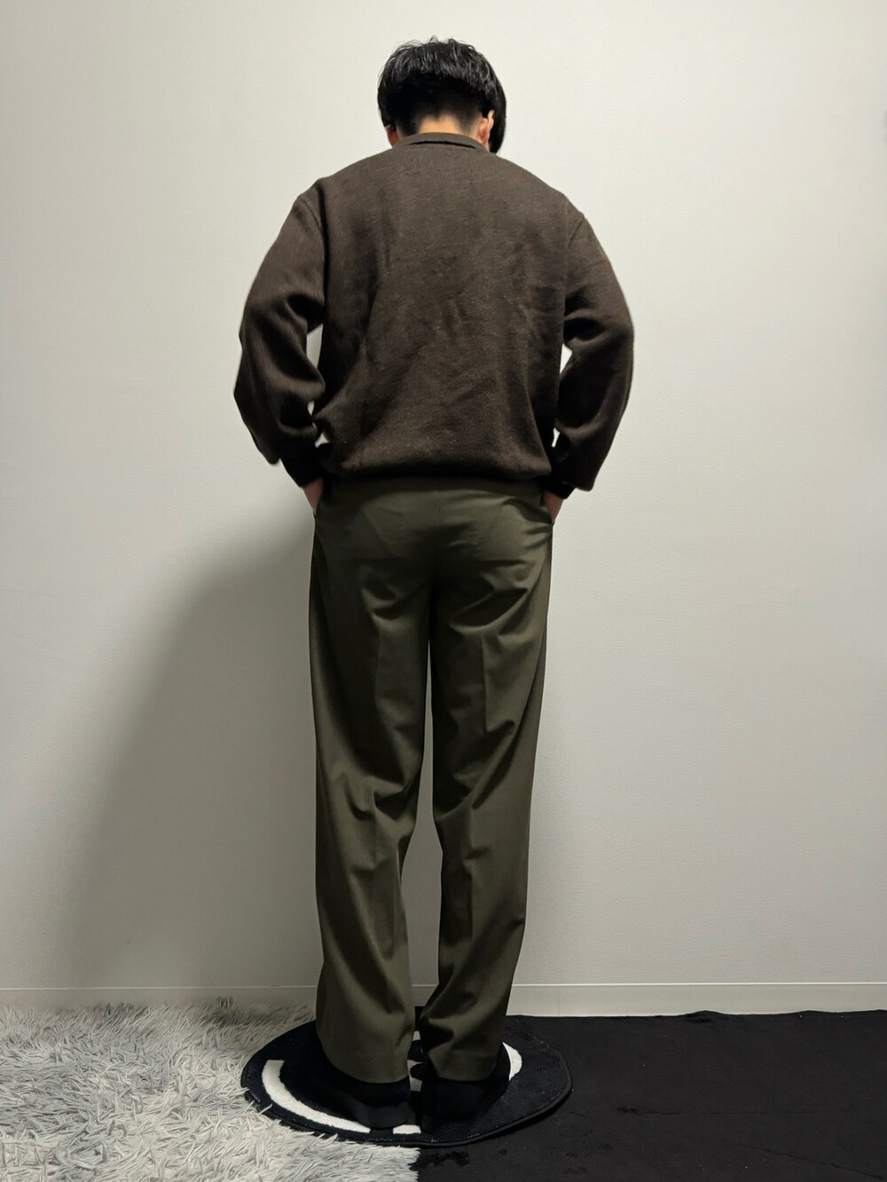 グリーン系のスラックス、ブラック系のモカシン/デッキシューズ、ブラウン系のポロシャツを着用したメンズの春コーディネートの4枚目の写真