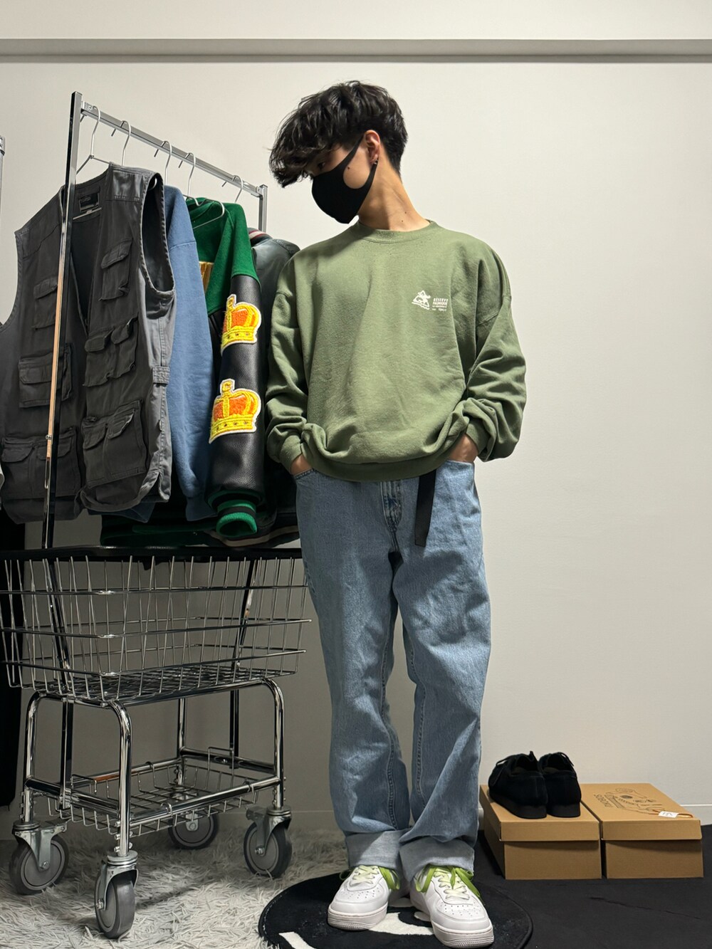 ブルー系のデニムパンツ、ホワイト系のスニーカー、グリーン系のスウェットを着用したメンズの冬コーディネートの2枚目の写真