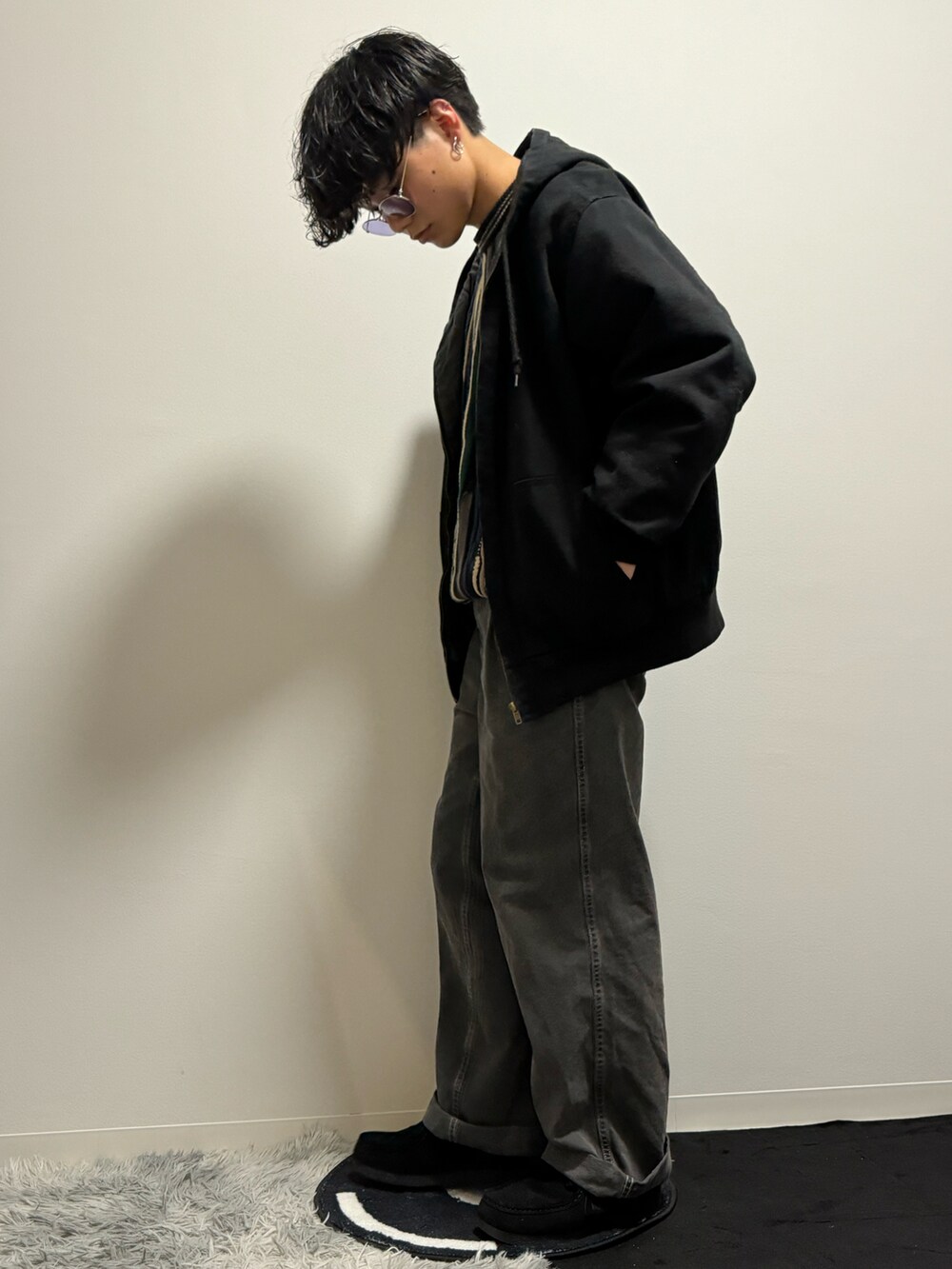 ブラック系のデニムパンツ、ブラック系のモカシン/デッキシューズ、ブラック系のニット/セーターを着用したメンズの春コーディネートの4枚目の写真