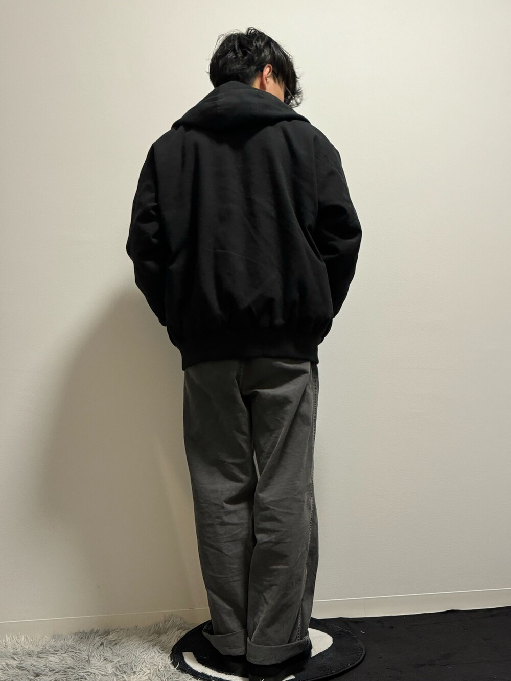 ブラック系のデニムパンツ、ブラック系のモカシン/デッキシューズ、ブラック系のニット/セーターを着用したメンズの春コーディネートの5枚目の写真
