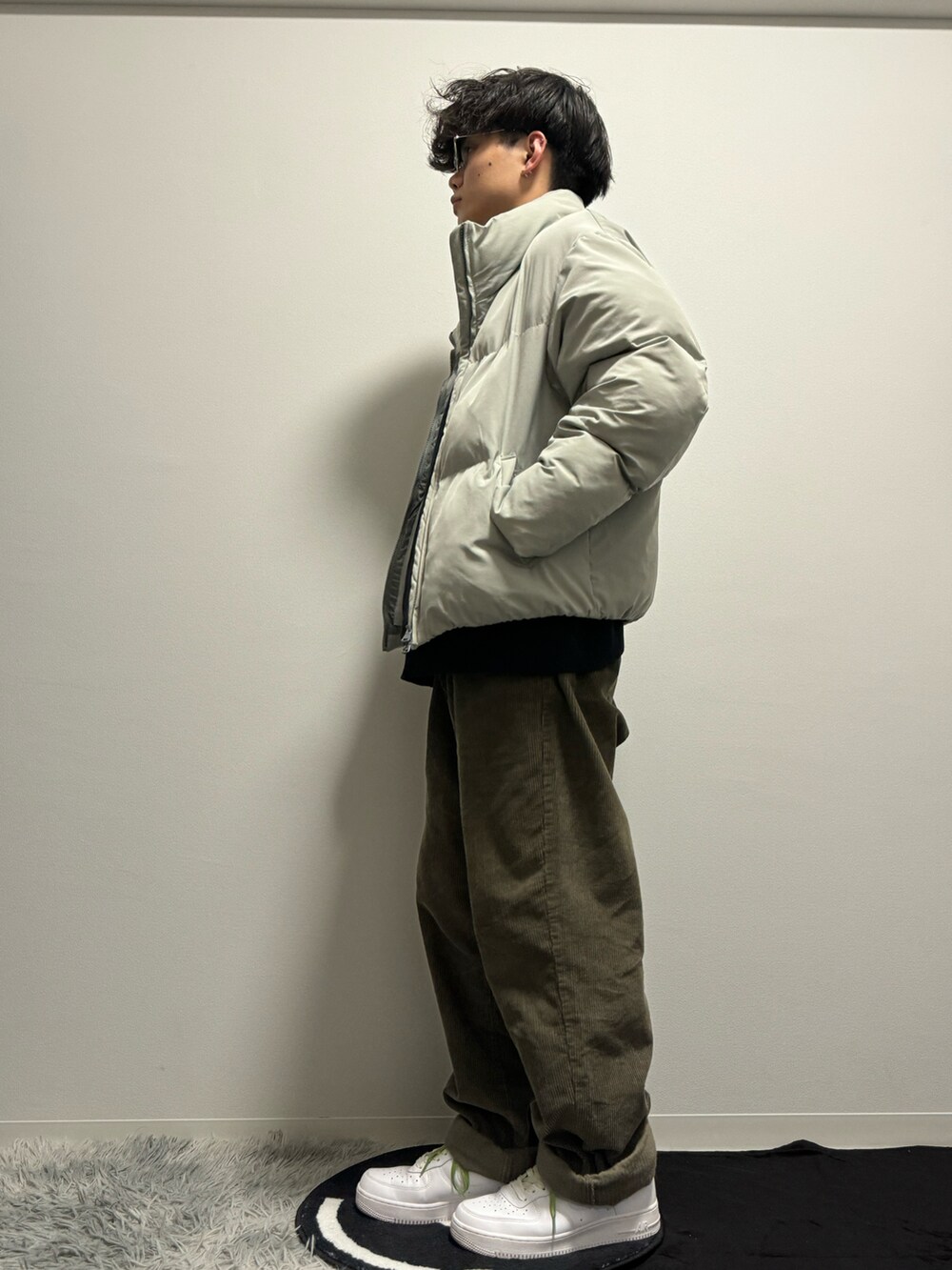 グレー系のダウンジャケット/コート、グリーン系のその他パンツ、ホワイト系のスニーカーを着用したメンズの春コーディネートの2枚目の写真
