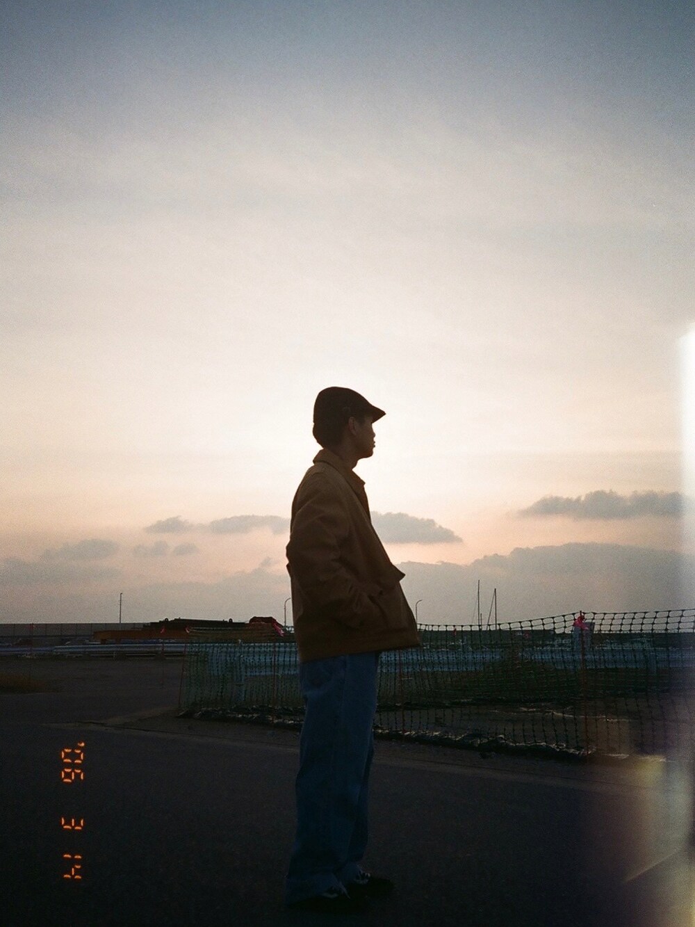 ブラウン系のスウェット、ベージュ系のブルゾン、ブルー系のデニムパンツを着用したメンズの春コーディネートの5枚目の写真