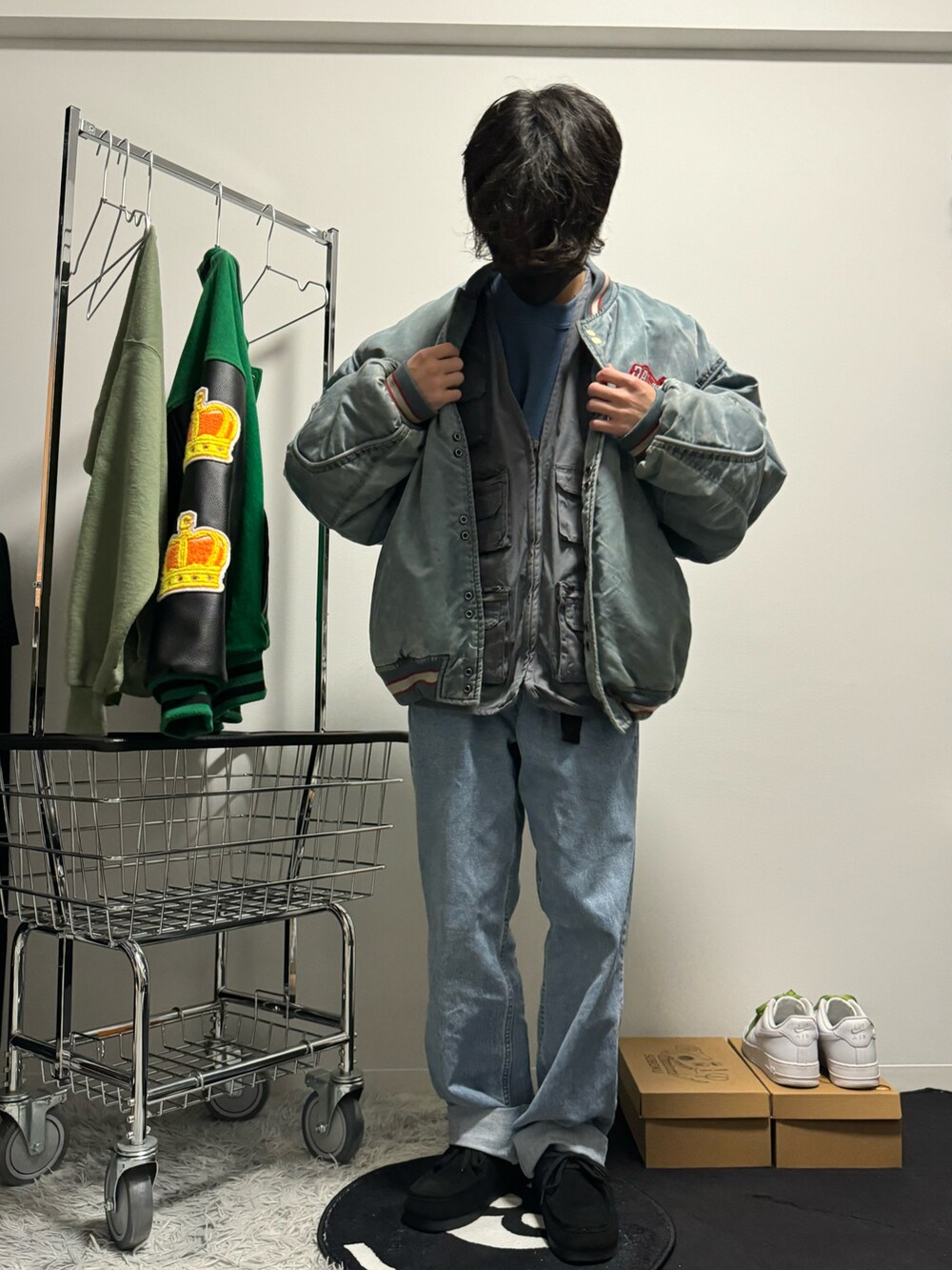 ブルー系のスタジャン、ブルー系のデニムパンツ、ブラック系のモカシン/デッキシューズを着用したメンズの春コーディネートの4枚目の写真