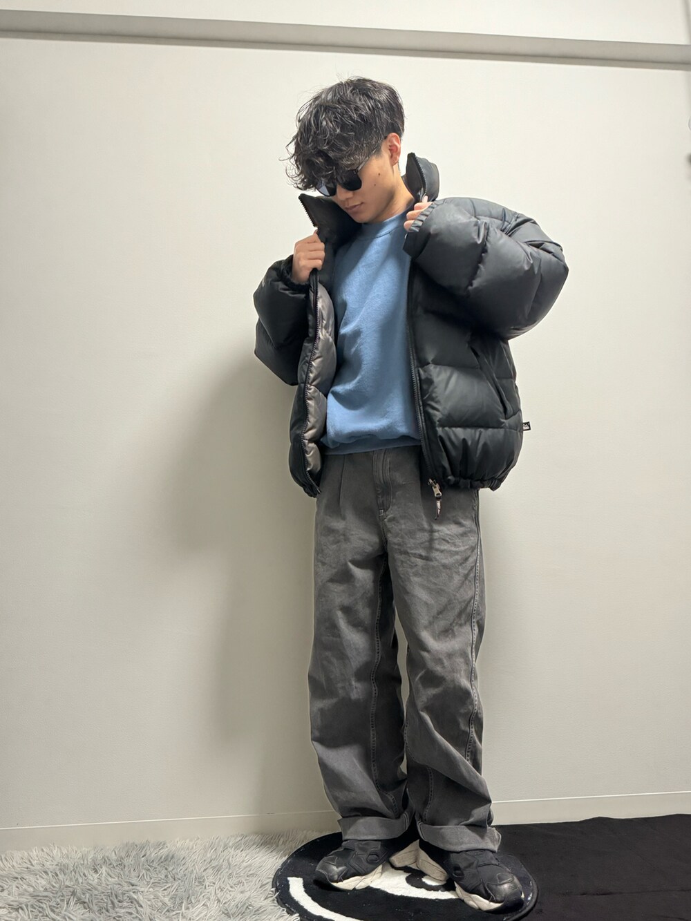 ブラック系のデニムパンツ、ブラック系のダウンジャケット/コート、ブルー系のスウェットを着用したメンズの冬コーディネートの3枚目の写真