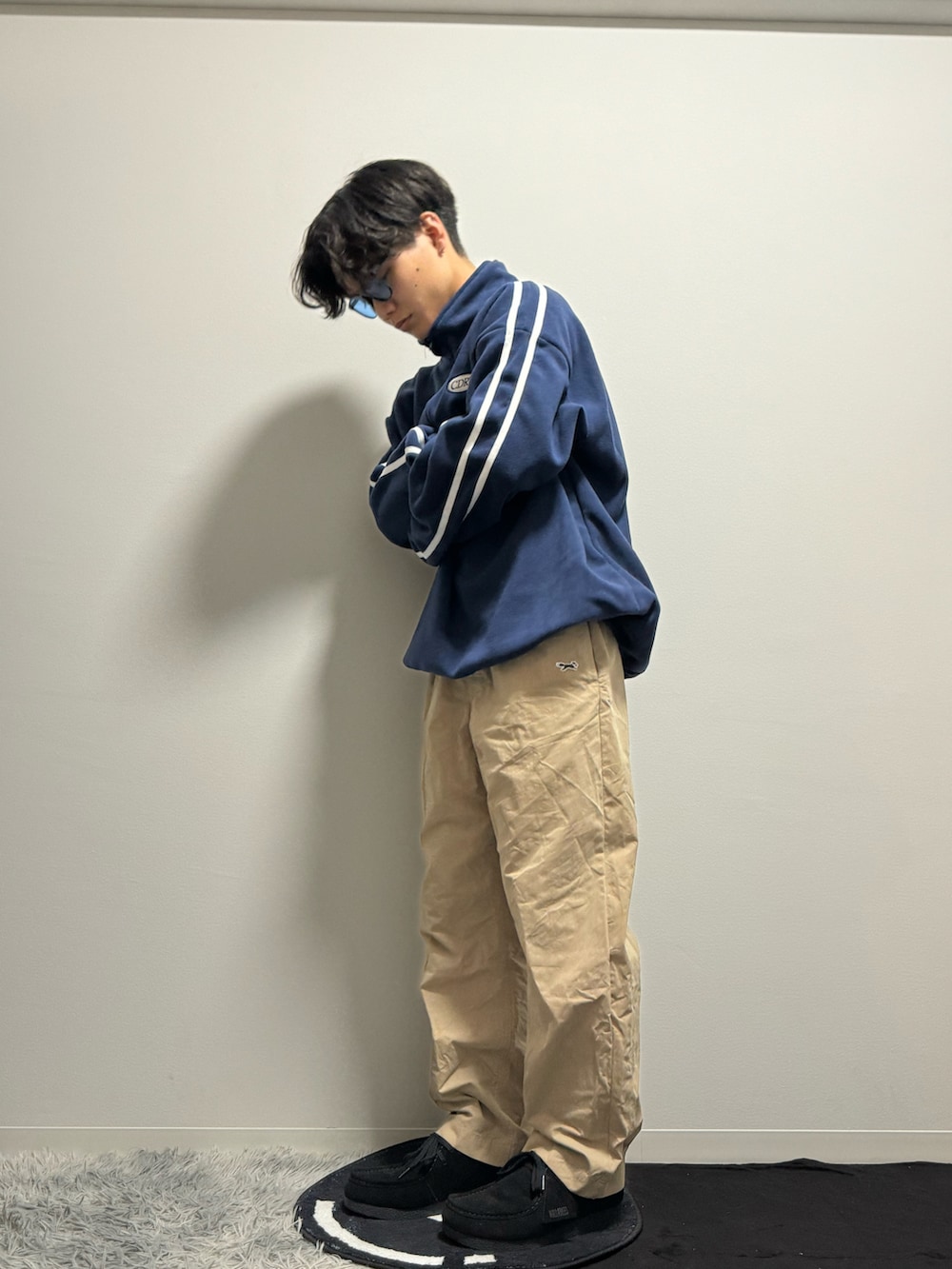 ブラック系のモカシン/デッキシューズ、ブルー系のスウェット、ベージュ系のパンツを着用したメンズの春コーディネートの2枚目の写真