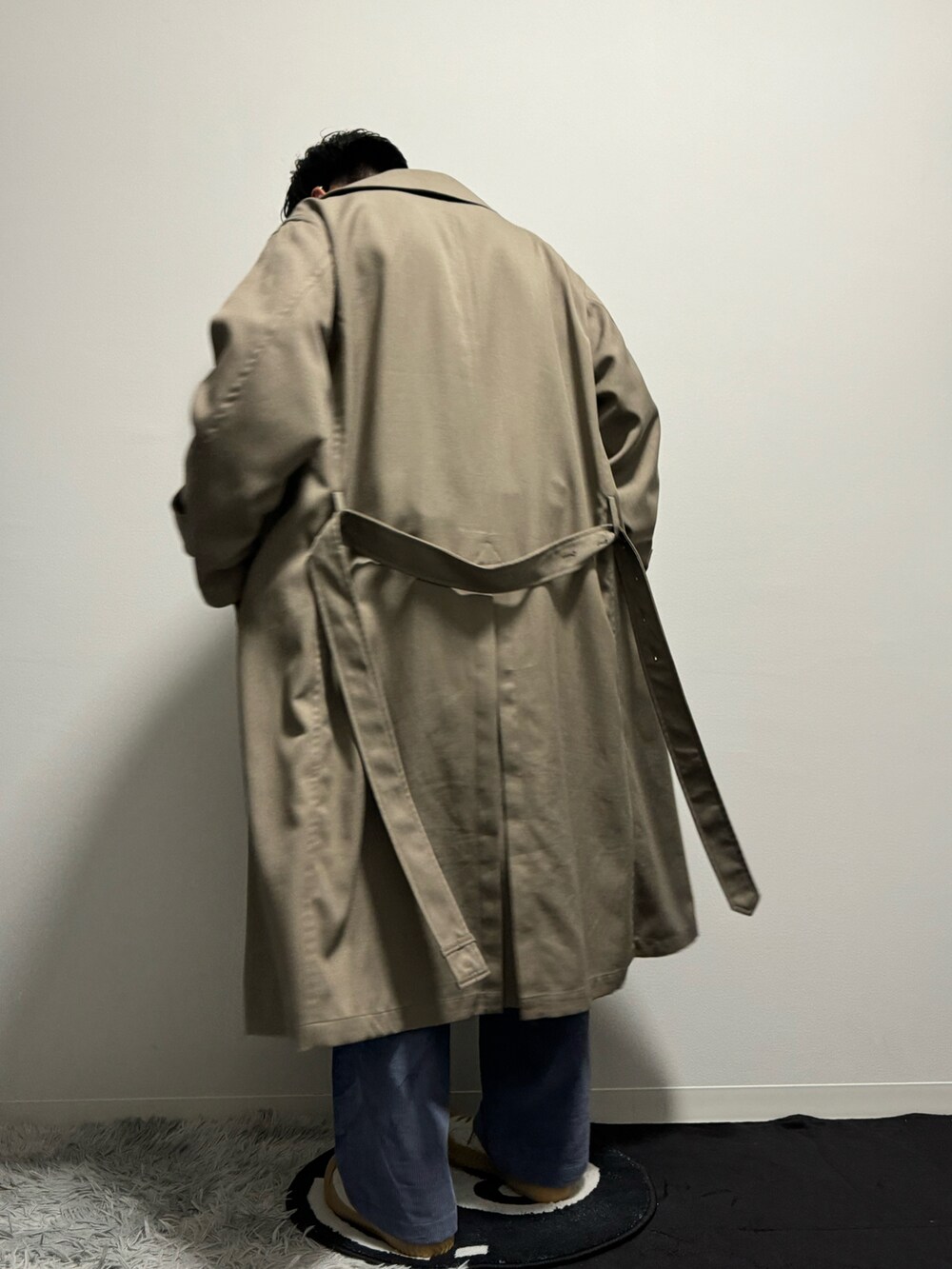 ベージュ系のトレンチコートを着用したメンズの春コーディネートの4枚目の写真