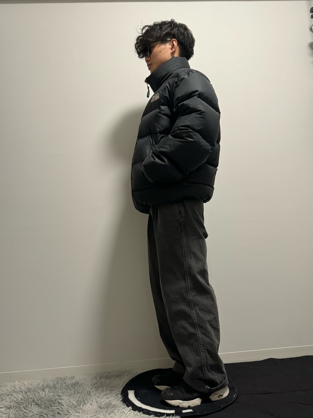 ブラック系のデニムパンツ、ブラック系のスニーカー、ブラック系のダウンジャケット/コートを着用したメンズの冬コーディネートの2枚目の写真