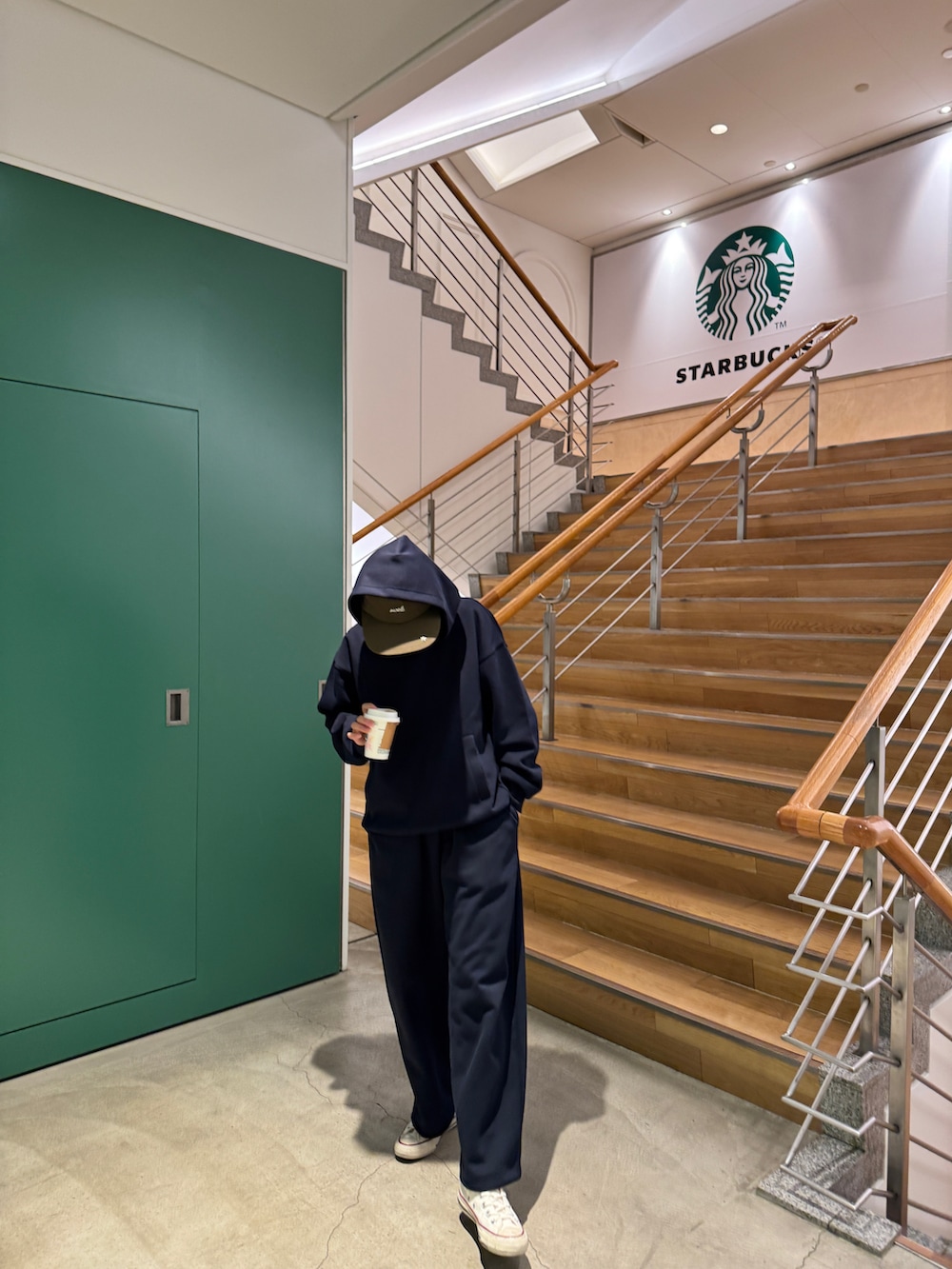 ブルー系のスウェットパンツ、ブルー系のパーカー、ホワイト系のスニーカーを着用したレディースの春コーディネートの2枚目の写真