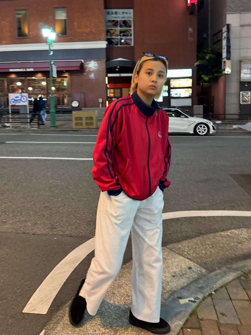 レッド系のジャケット/アウター、グレー系のスウェットパンツ、ブラック系のローファーを着用したレディースの冬コーディネートの2枚目の写真