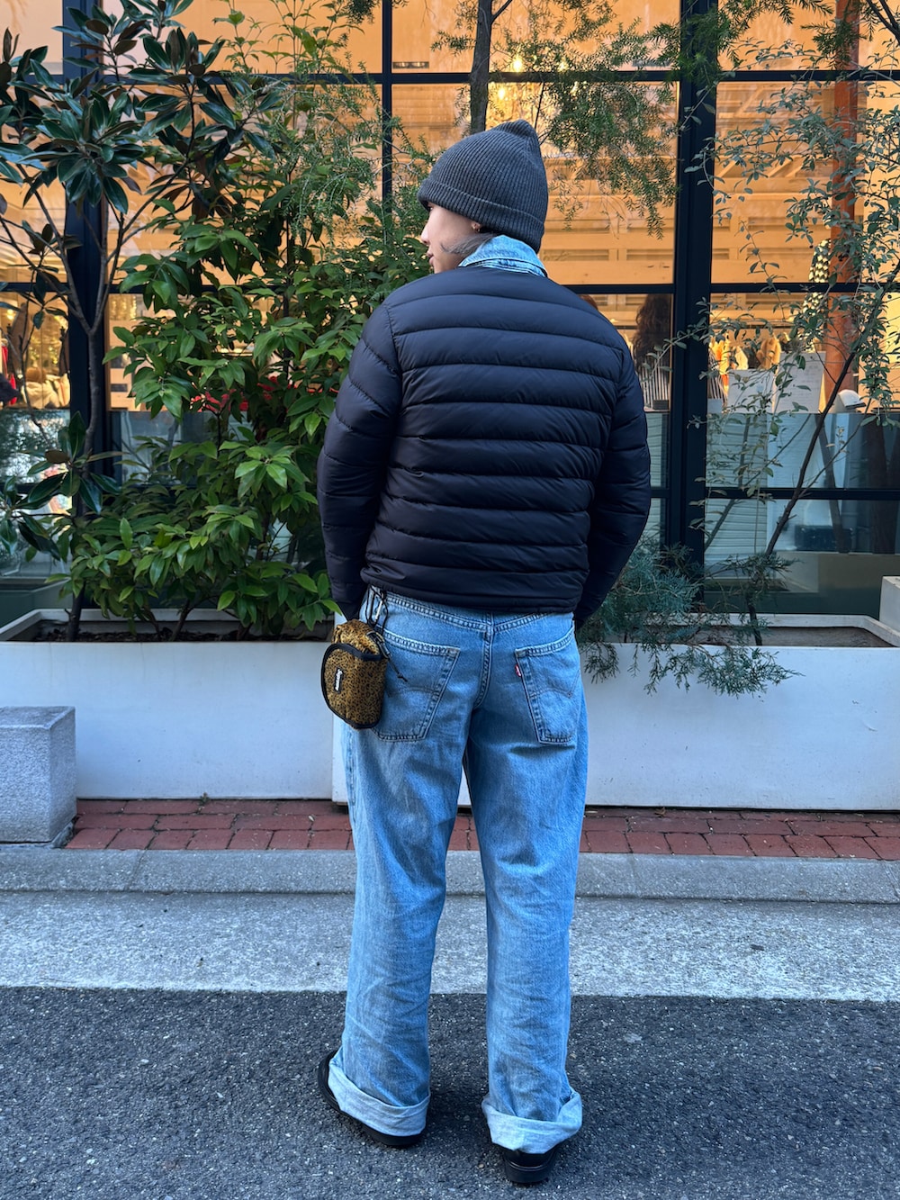 ブラック系のダウンジャケット/コート、ブルー系のつなぎ/オールインワン、ブラック系のローファーを着用したレディースの春コーディネートの3枚目の写真