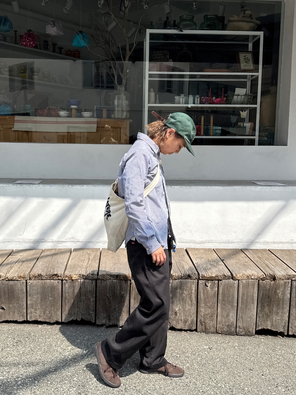 ブラック系のチノパンツ、ブラウン系のスニーカー、ブルー系のシャツ/ブラウスを着用したレディースの春コーディネートの3枚目の写真