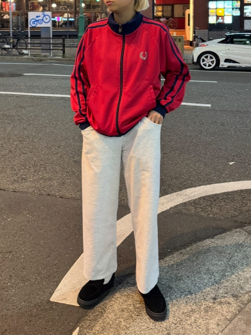 レッド系のジャケット/アウター、グレー系のスウェットパンツ、ブラック系のローファーを着用したレディースの冬コーディネートの3枚目の写真