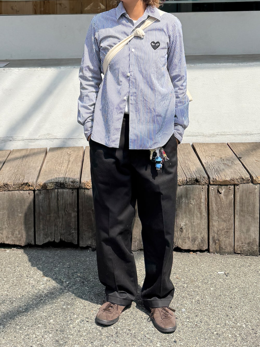 ブラック系のチノパンツ、ブラウン系のスニーカー、ブルー系のシャツ/ブラウスを着用したレディースの春コーディネートの2枚目の写真