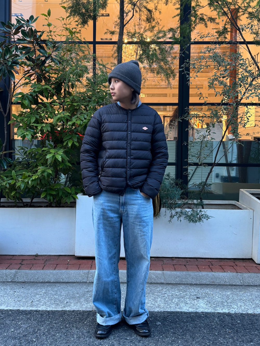 ブラック系のダウンジャケット/コート、ブルー系のつなぎ/オールインワン、ブラック系のローファーを着用したレディースの春コーディネートの2枚目の写真