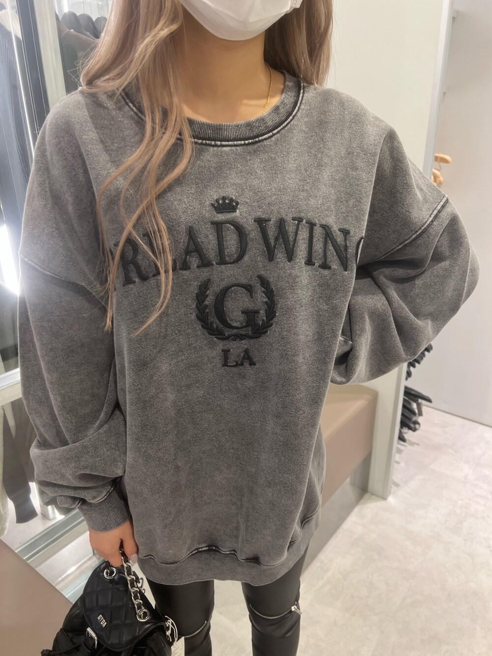 グレー系のスウェット、ブラック系のパンプス、ブラック系のレギンス/スパッツを着用したレディースの冬コーディネートの3枚目の写真