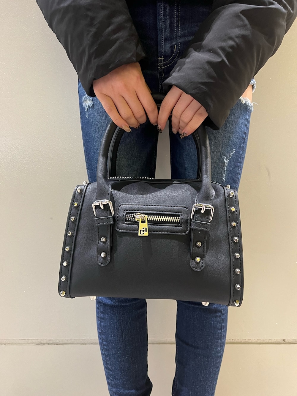 ブラック系のダウンジャケット/コート、ブルー系のデニムパンツ、ブラック系のブーツを着用したレディースの秋コーディネートの5枚目の写真