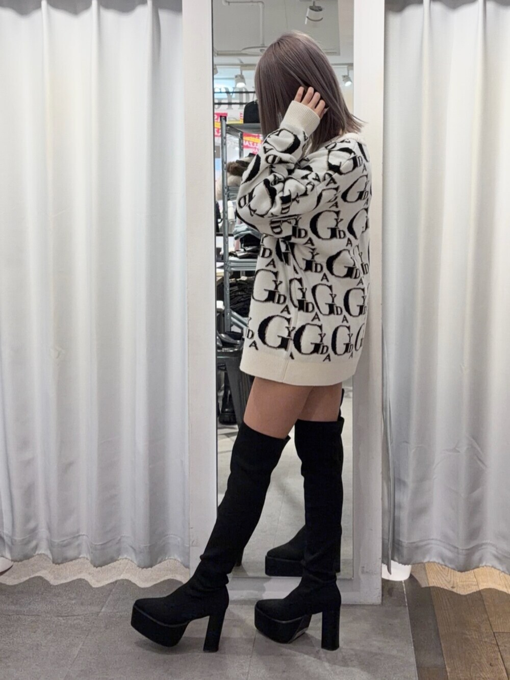 ブラック系のブーツ、ホワイト系のニット/セーターを着用したレディースの冬コーディネートの3枚目の写真