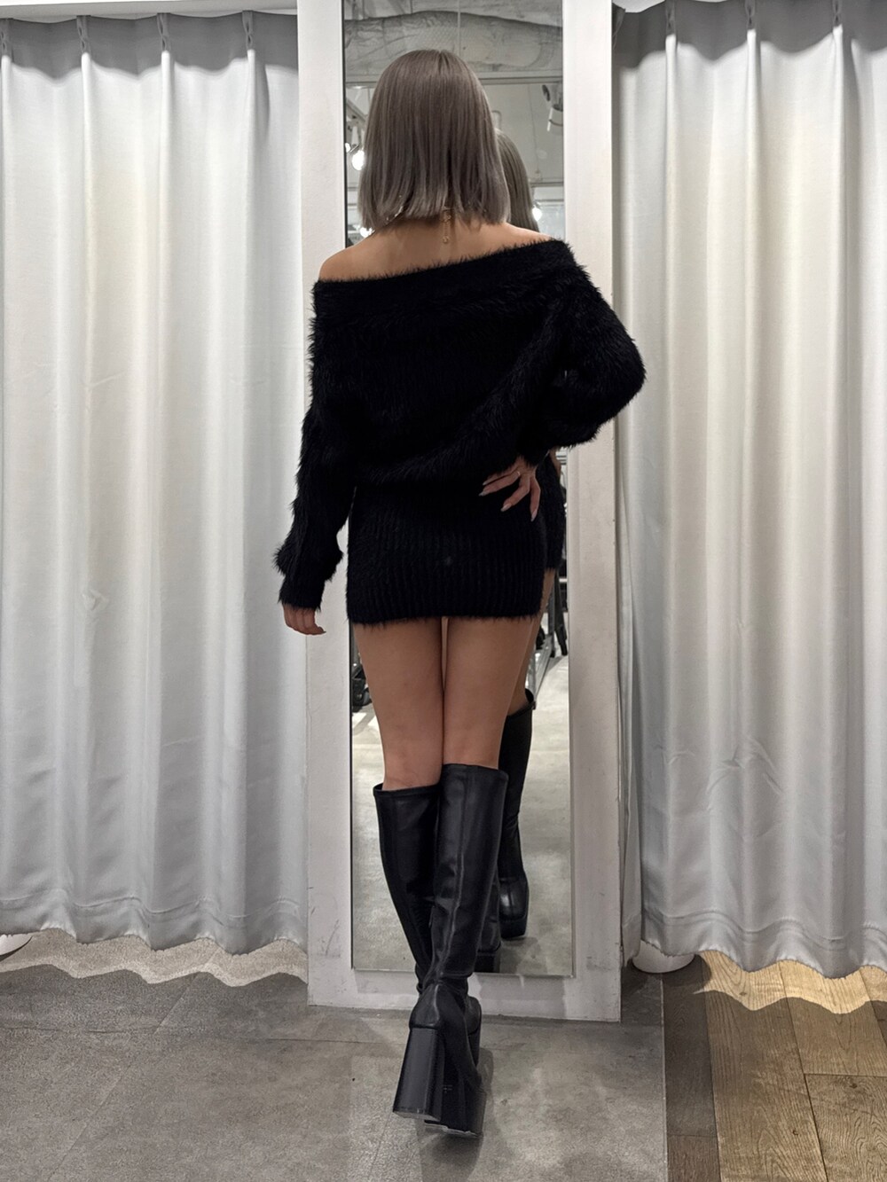 ブラック系のワンピース、ブラック系のブーツを着用したレディースの秋コーディネートの2枚目の写真