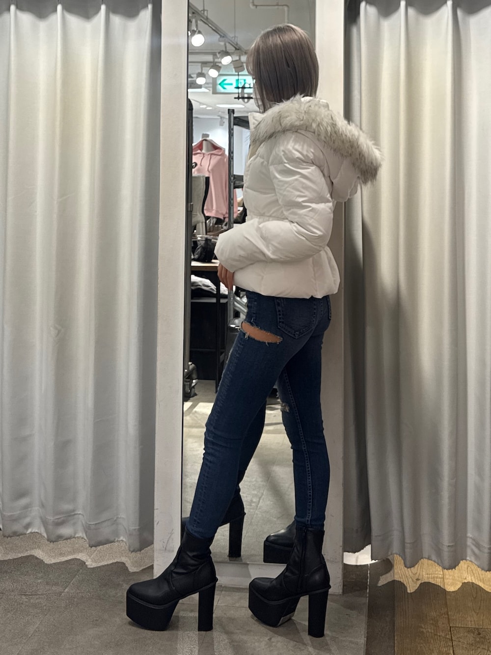 ホワイト系のダウンジャケット/コート、ブルー系のデニムパンツ、ブラック系のブーツを着用したレディースの秋コーディネートの3枚目の写真